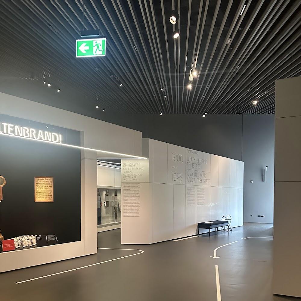 A museum hallway with white walls and a bench.